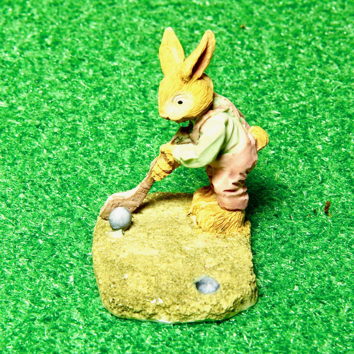 A statue, a rabbit, a golfer