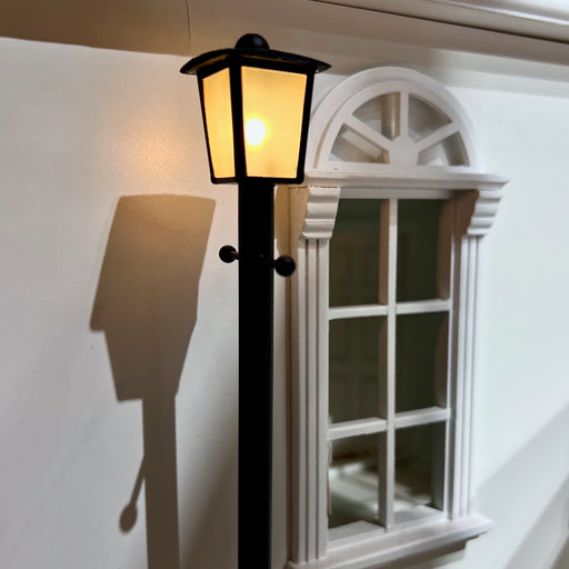 Valaistu nukkekodin katulyhty.