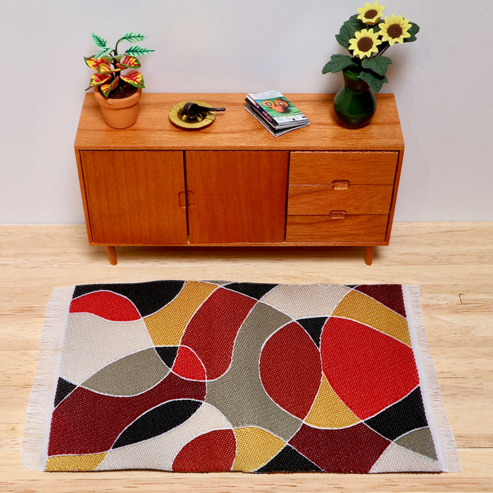 Värikäs matto ja tiikkikaluste.