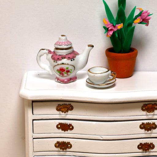 Pienikokoinen teetarjoilu lipastolla.