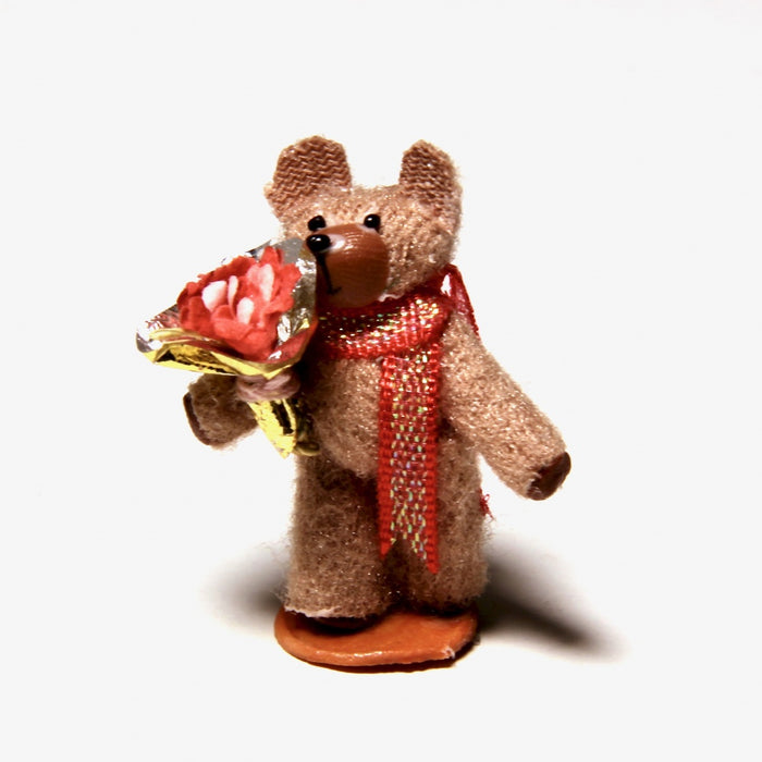 Medium brown teddy bear with a bouquet of flowers