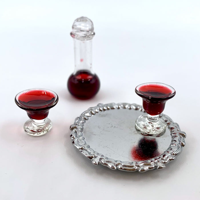 A wine carafe and glasses of red wine on a tray