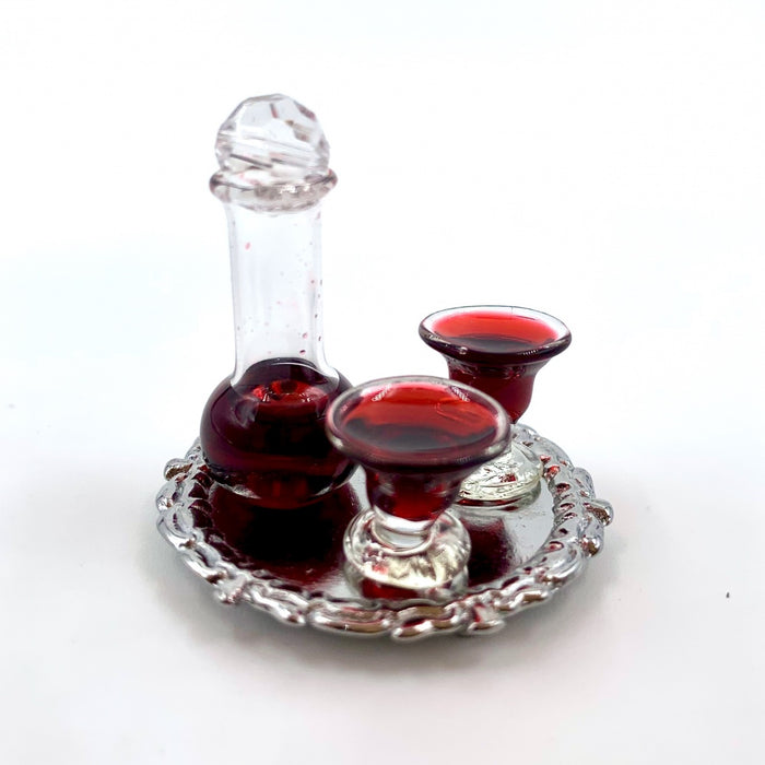 A wine carafe and glasses of red wine on a tray